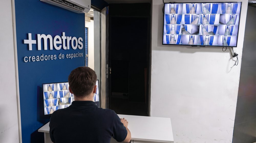 Sala de monitoreo con la grilla de cámaras de los pasillos en pantalla